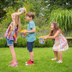 three young children playing in the grass