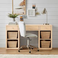 a desk with two baskets underneath it and a chair in front of it, on top of a wooden floor