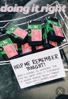 a bunch of pink and green tags are on a wire with a sign that says help me remember tonight