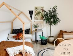 a bed room with a wooden frame and a small house shaped bed next to a potted plant