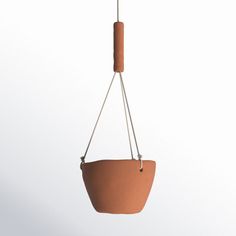 a clay hanging planter with a wooden handle