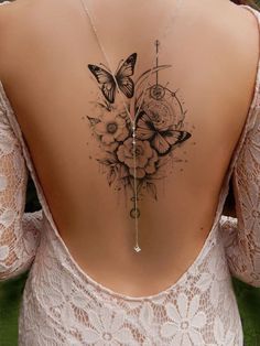 the back of a woman's neck with flowers and butterflies on it