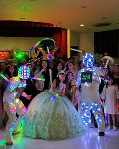 a group of people standing around each other in front of some costumed characters on the dance floor