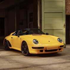 a yellow sports car parked in front of a garage