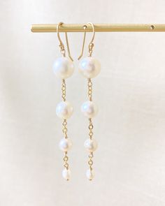 These pearl drop earrings are perfect for any occasion, whether it's a casual brunch or a spring wedding. The creamy white off-round freshwater pearls elegantly dangle from gold fill ear wires, giving a timeless and versatile look. Ear backs included for a secure fit. Drop length: 2.5 inches from the top of the ear wire Pearl sizes: 9-4 mm Materials: gold fill, cultured freshwater pearls Gift box included. Pearl Gifts, Silver Jewelry Necklace, White Freshwater Pearl, Freshwater Cultured Pearls, February Birth Stone, Pearl Size, Pearl Drop Earrings, Pearl Drop, Creamy White