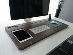 a computer desk with a tablet, keyboard and mouse