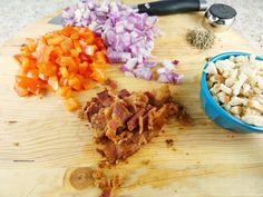 chopped up vegetables are on a cutting board next to a bowl with diced meat