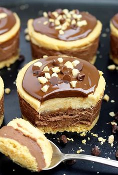 there are many desserts on the tray with chocolate frosting and nuts around them