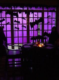 two people sitting at a table with bats on the window