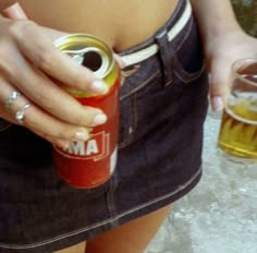 a woman holding a can of beer in her right hand