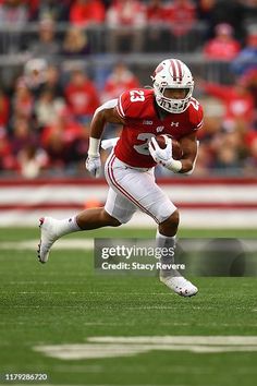 a football player running with the ball in his hands during a game against american football team