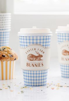 three cups with bunny bunnies on them sitting next to muffins and cupcakes