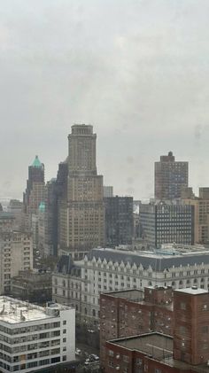 the city is full of tall buildings and skyscrapers on a cloudy day in winter