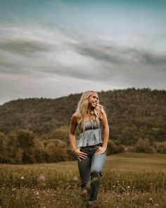 a woman standing in the middle of a field