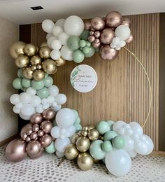 the balloon arch is decorated with gold, white and mint green balloons for a wedding reception