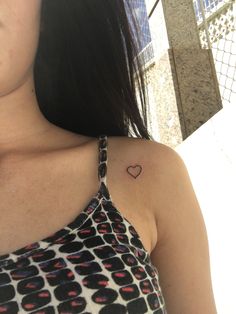 a woman with a small heart tattoo on her shoulder