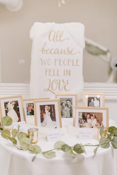 a table topped with pictures and greenery next to a white sign that says life because two people fell in love