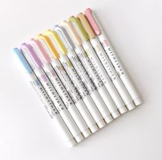 six different colored pens lined up in a row on a white surface with the same color