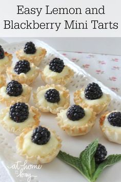 blackberry mini tarts on a white plate with mint leaves and blackberries in the middle