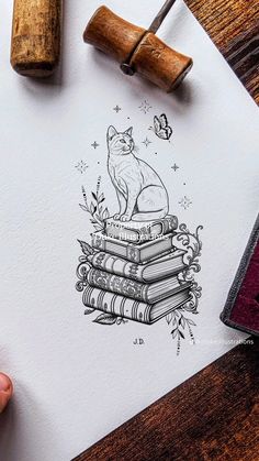 a drawing of a cat sitting on top of a stack of books next to a rubber stamp