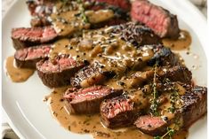 steak with gravy and sauce on a white plate, ready to be eaten