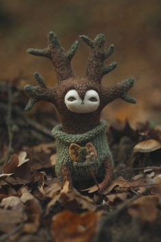 a small stuffed animal wearing a green sweater