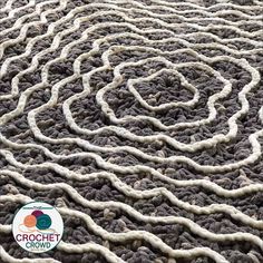 the carpet is made up of white and gray yarn with an oval design on it