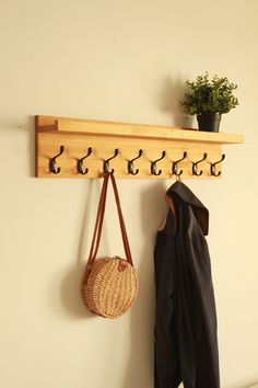 a coat rack with hooks and two purses hanging from it's sides on a wall