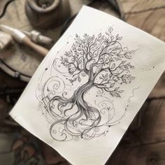 a drawing of a tree with swirls and leaves on it's paper, next to a pair of scissors