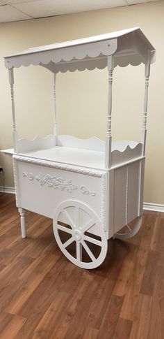 a white wooden cart with wheels on the floor