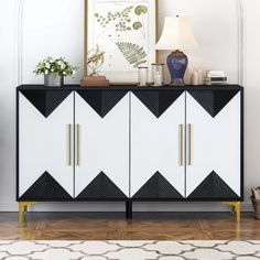 a white and black sideboard with gold handles in a living room next to a lamp