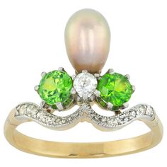 A Belle Epoque natural pearl, garnet and diamond aigrette ring, the greyish pink pearl accompanied by GCS report stating to be natural saltwater, set within two round faceted demantoid garnets and one old-cut diamond, the platinum and yellow gold mount with diamond-set shoulders, circa 1900, bearing French assay marks, the head measuring approximately 1.4cm, gross weight 3.20 grams. Finger size L This ring is in very good condition. Unmarked, tested as 18ct gold and platinum. A splendid and eleg Natural Pearl Ring, Garnet And Diamond Ring, Diamond Rings With Price, Tiara Ring, Demantoid Garnet, Edwardian Jewelry, Pearl And Diamond Ring, Antique Diamond Rings, Natural Pearl