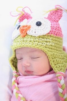 a baby is wearing a crocheted hat and sleeping