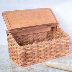 an empty basket sitting on top of a counter next to a wooden board and knife