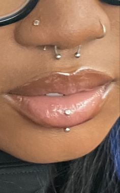 a close up of a woman's nose with piercings on her nose and lip