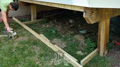 a man is working on the side of a house with wood planks attached to it