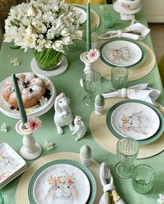 the table is set with plates, cups, and other dishes for easter dinner or brunch