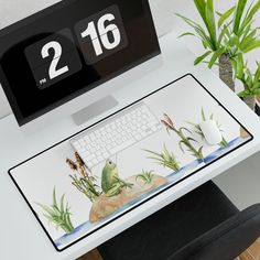 a computer desk with a clock and keyboard on it, next to a potted plant