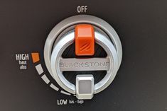 an orange knob on a black and silver control panel with the words blackstone written below it