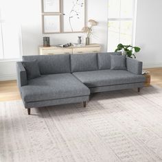 a gray couch sitting on top of a white rug