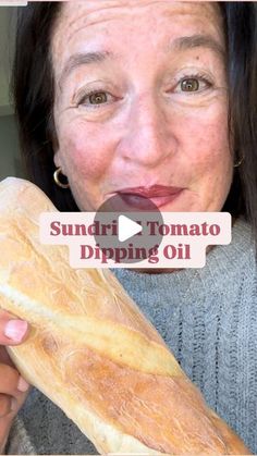 a woman holding a loaf of bread with the words sundri tomato dipping oil