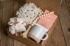 an open box with items inside on a wooden floor next to a cup and saucer