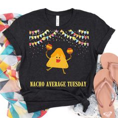 Nacho Average Tuesday T-Shirt, Express your love for Taco Tuesday, Tex-Mex Flair: Show your love for Tacos y mid-week fiestas. Who cares if it's Tuesday. Meet your friends and fully engorge yourself with cervezas and más Tacos. Make sure to show 'em this awesome shirt while you do it.  Premium Quality  Quality Comfort: Crafted from 100% soft, breathable cotton, this tee ensures you're comfortable while showcasing your dedication to fun and Mexican cuisine. Tailored Fit: Available in both unisex and tailored fits, this shirt complements every body type.  Quirky Elegance  This shirt will be a great conversation starter, while offering a bold yet elegant statement. Fun Graphic Print Tops For Cinco De Mayo, Casual Crew Neck T-shirt For Fiesta, Fun Tops With Funny Print For Cinco De Mayo, Fun Cinco De Mayo Tops With Funny Print, Fun Cinco De Mayo Funny Print Tops, Graphic Print Short Sleeve T-shirt For Fiesta, Cinco De Mayo Fun Crew Neck T-shirt, Fun Cinco De Mayo Crew Neck T-shirt, Fun Crew Neck T-shirt For Cinco De Mayo