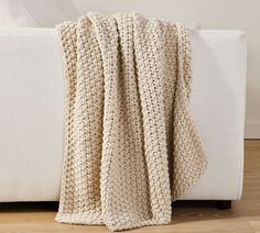 a crocheted blanket sitting on top of a white couch