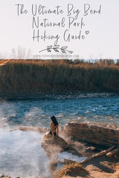 a woman sitting on top of a rock next to a river with steam rising from it