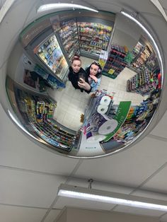 two people are seen from above in a fish eye view mirror at a grocery store