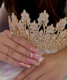 a close up of a person wearing a tiara and manicures on their hands