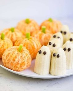 a white plate topped with mini pumpkins and jack - o'- lantern cookies