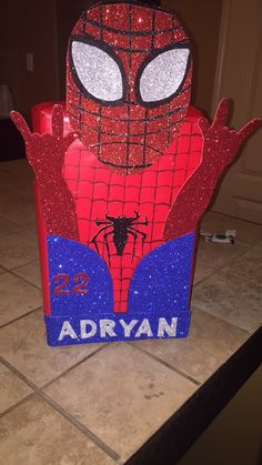 a cardboard box with a spiderman face on it's side and the words adryan written in blue