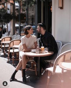 a man and woman sitting at an outdoor table